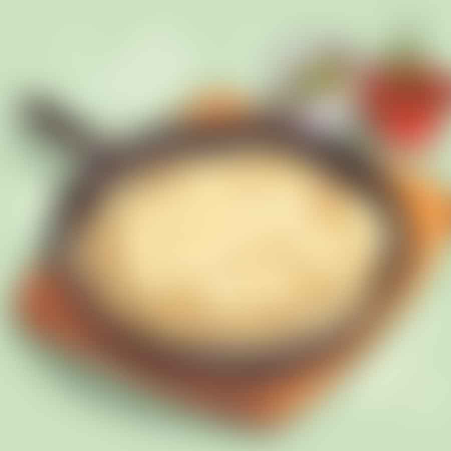 A tortilla being warmed in a skillet on a stovetop.